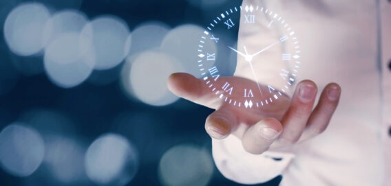Abovo Media - businessman-holding-clock-symbol-blurred-background